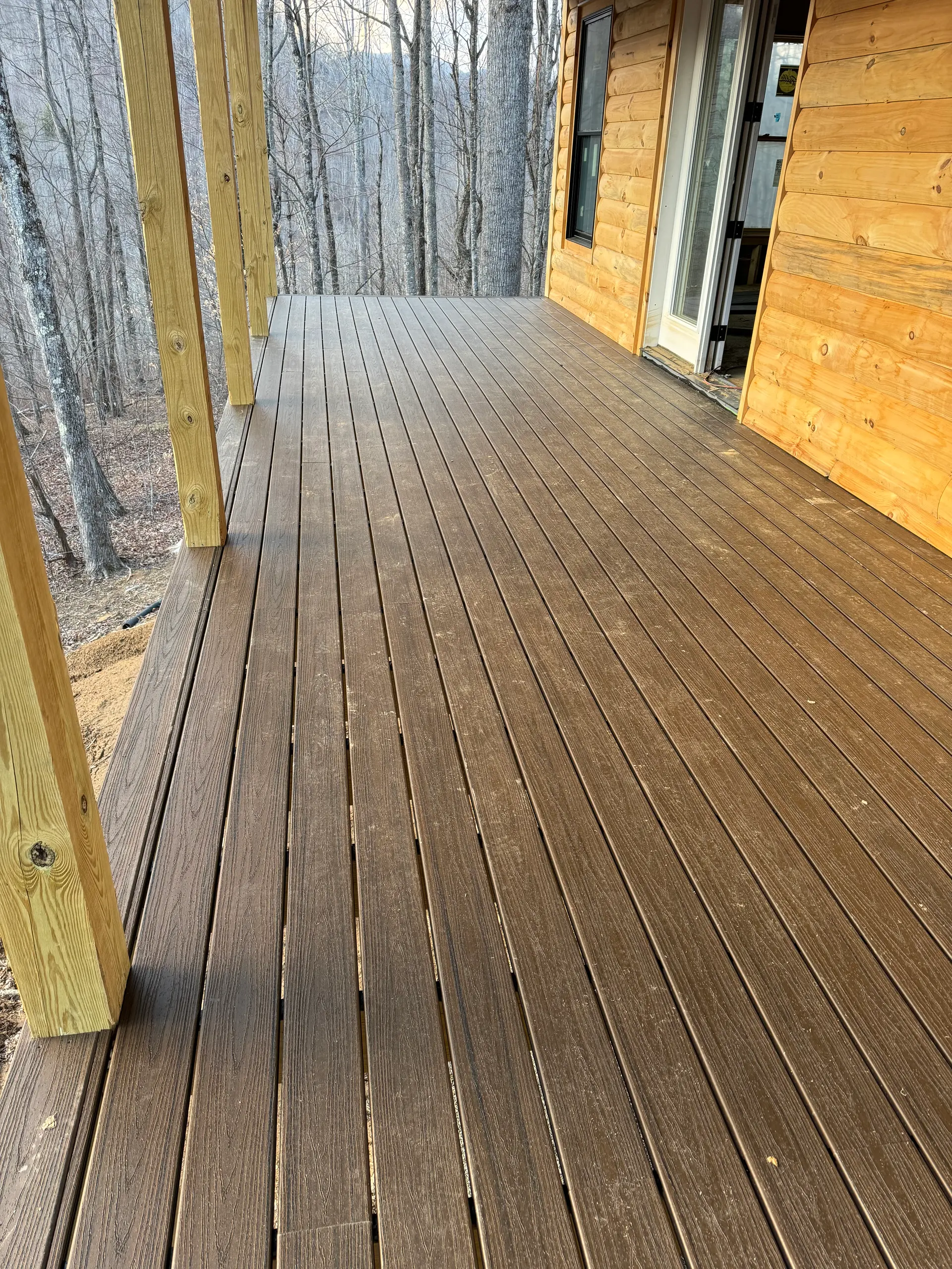 New dark-plank deck along a log-sided home