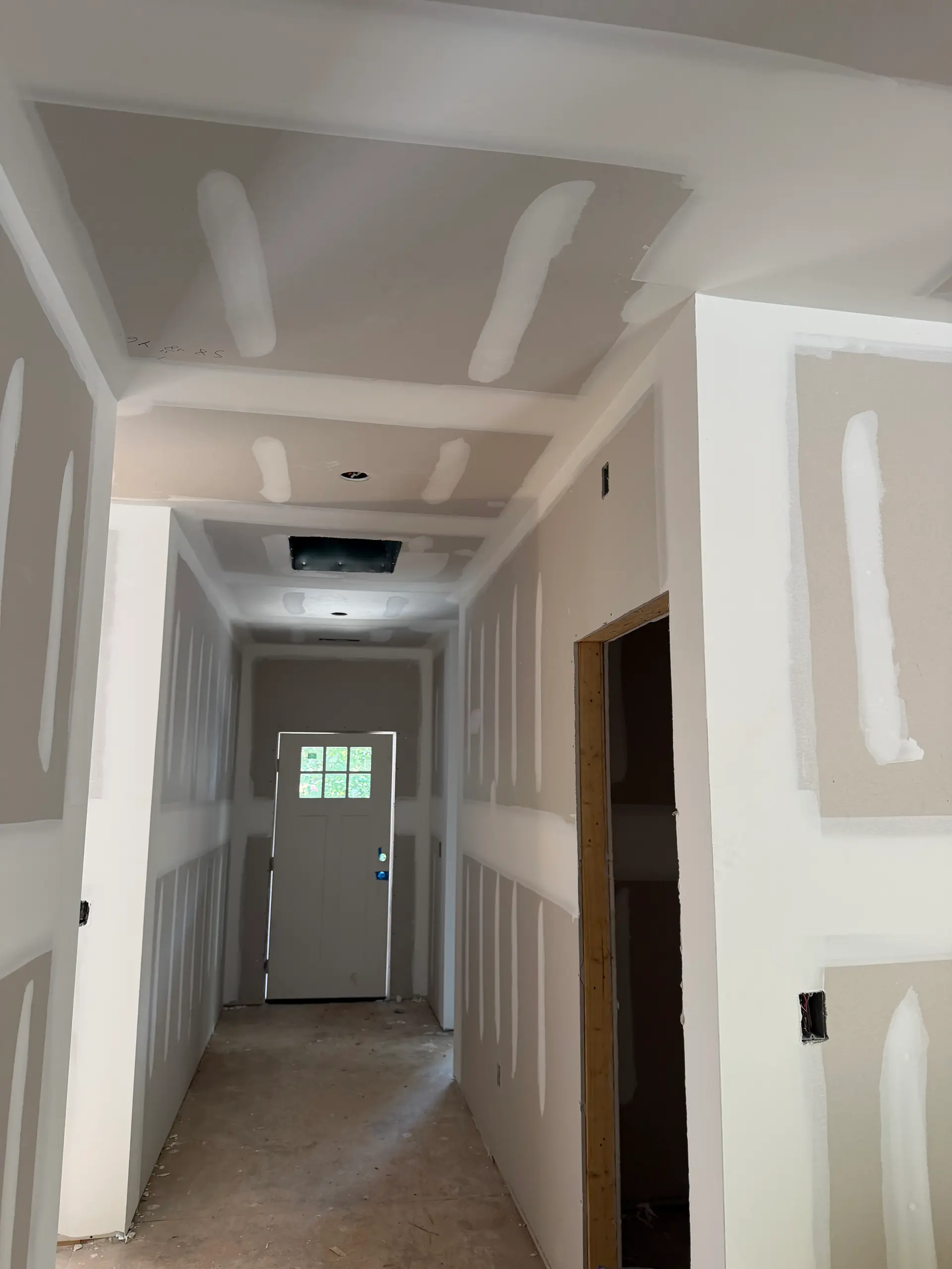 Interior hallway after drywall hang and first coat of mud