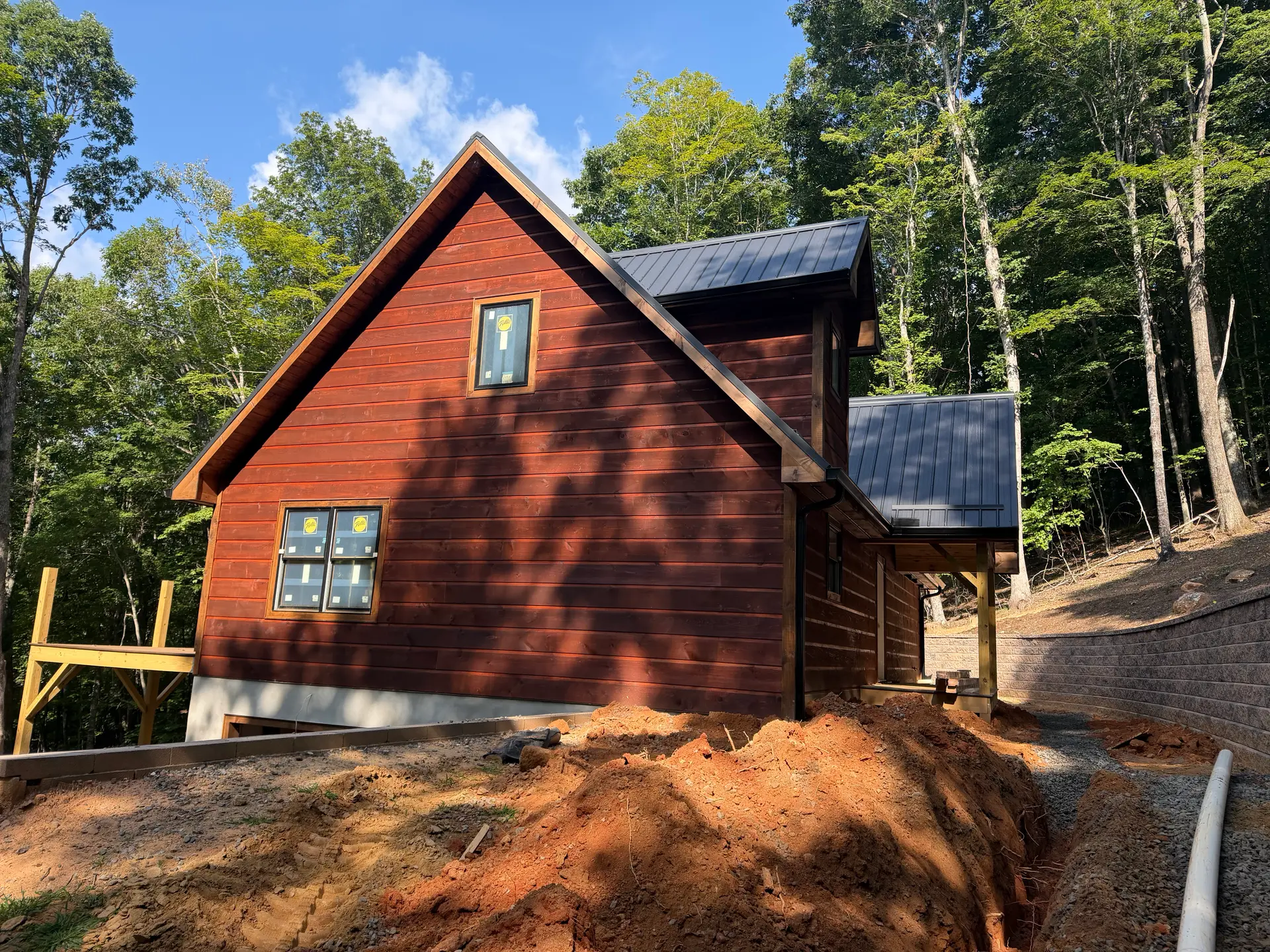 Two-story wood-sided home with charcoal metal roof on a wooded Danville-area lot