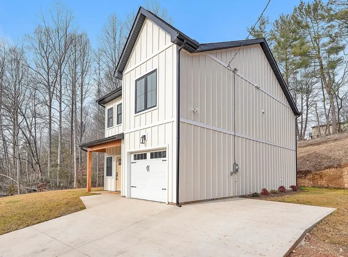 Completed two-story residence with black trim and a wood-accent porch by Alta Homes